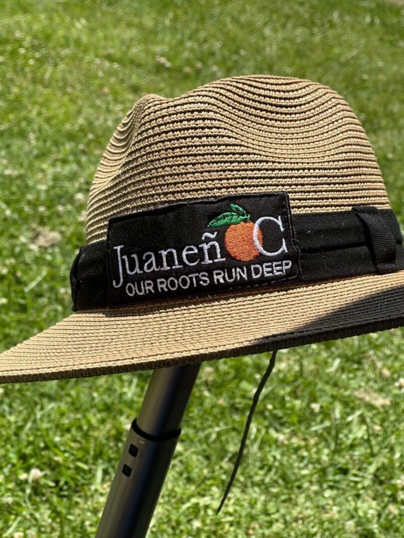Straw hat with embroidered patch on grass.