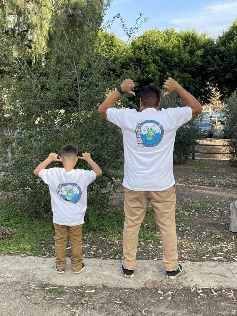 Two people flexing in matching Earth shirts.