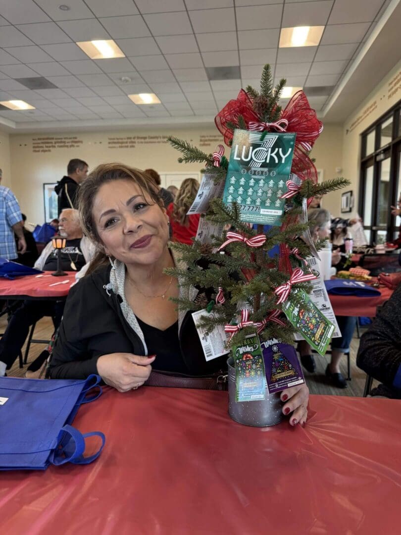Woman with decorative tree centerpiece, smiling.