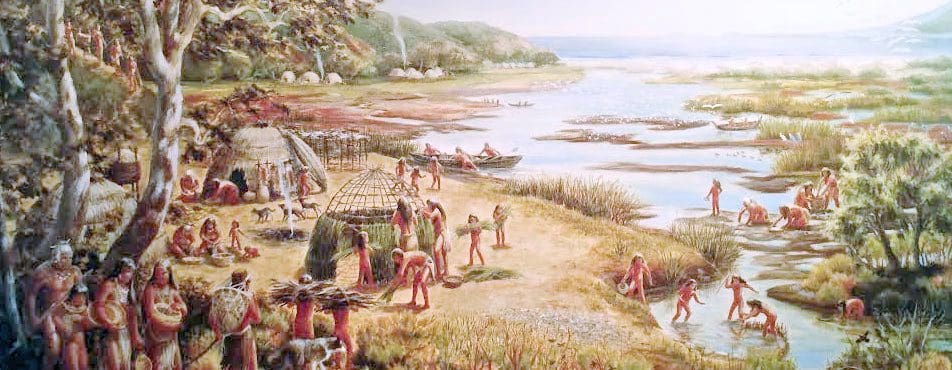 Indigenous people by river, engaging in activities.