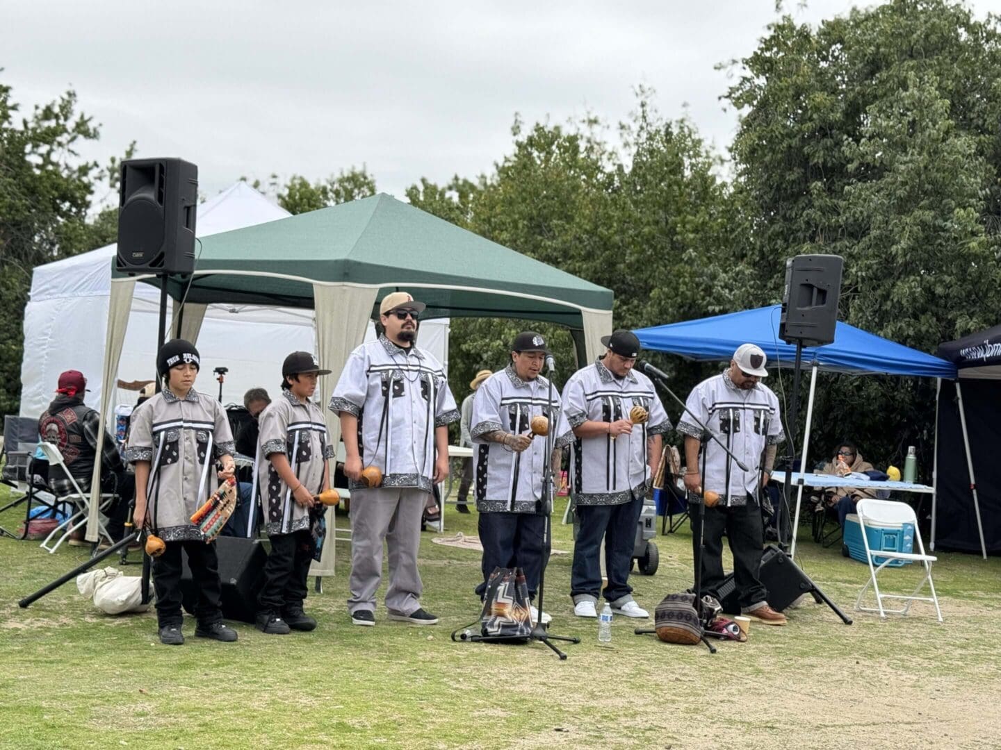 A band performs outdoors wearing matching striped shirts.