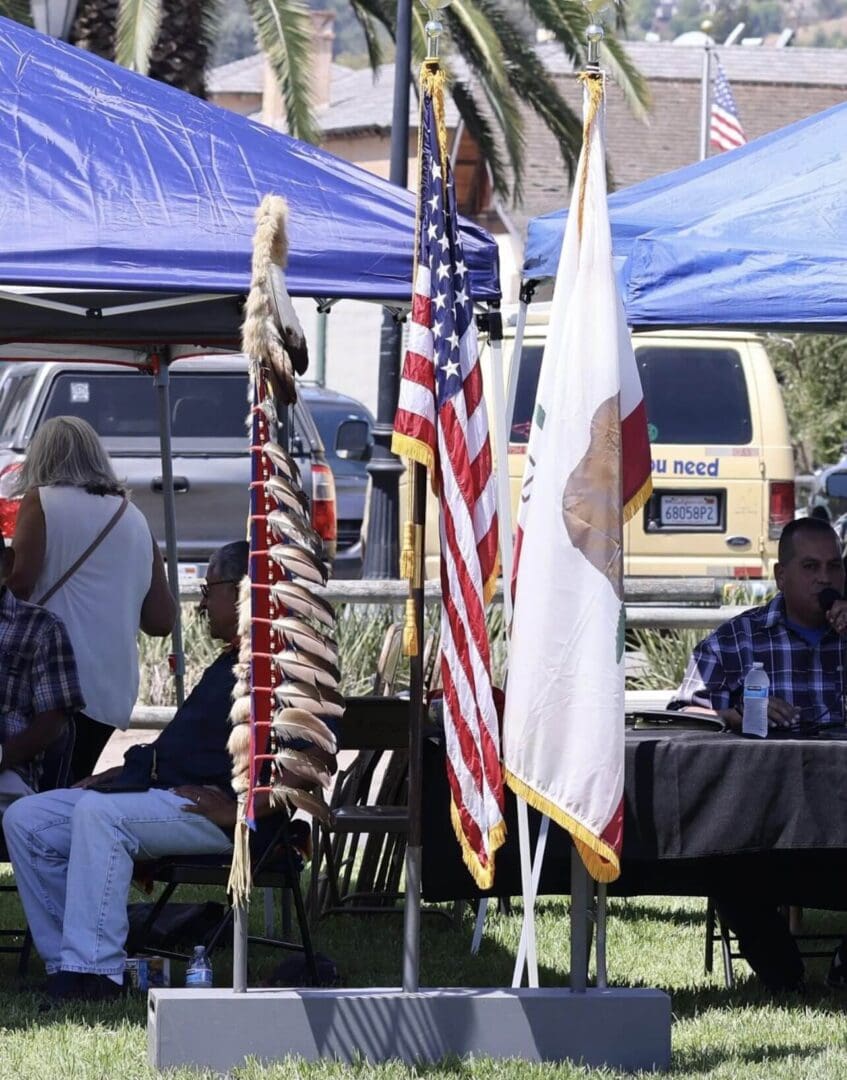 Native American event with traditional attire and flags on display.