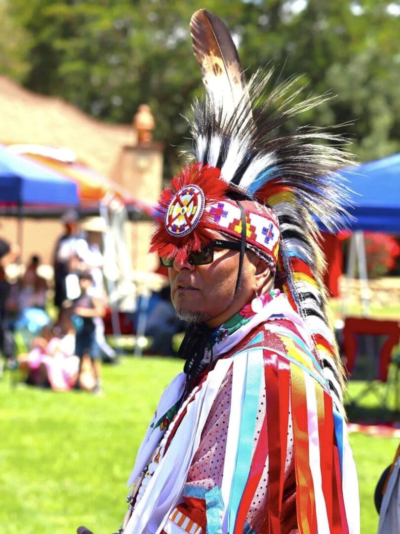 A man in traditional Native American regalia at a cultural event.