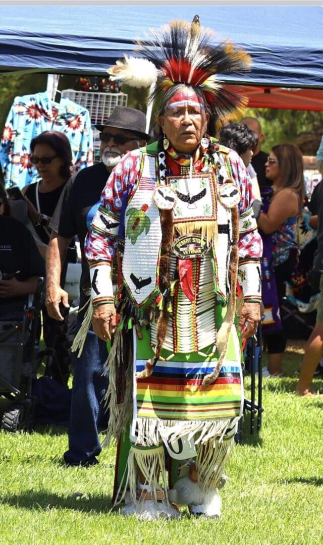 A person dressed in colorful traditional Native American regalia at a cultural event.