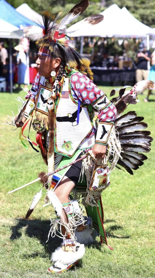 Native American dancer in traditional regalia performing at a cultural event.