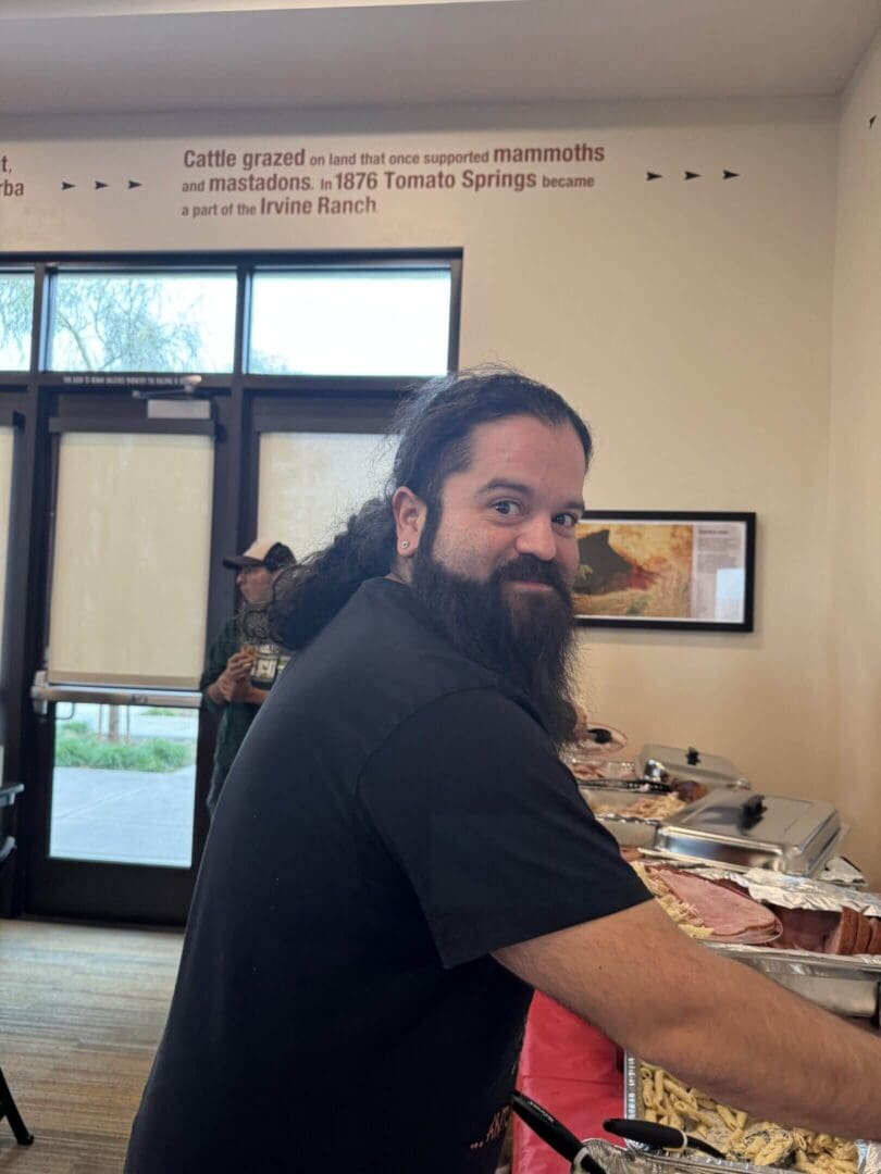 Man serving food at a buffet table.