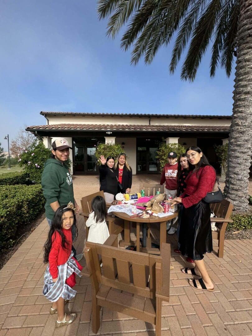 Group gathered around outdoor table with crafts.