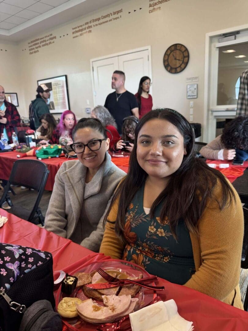 Two women sitting at a festive gathering.