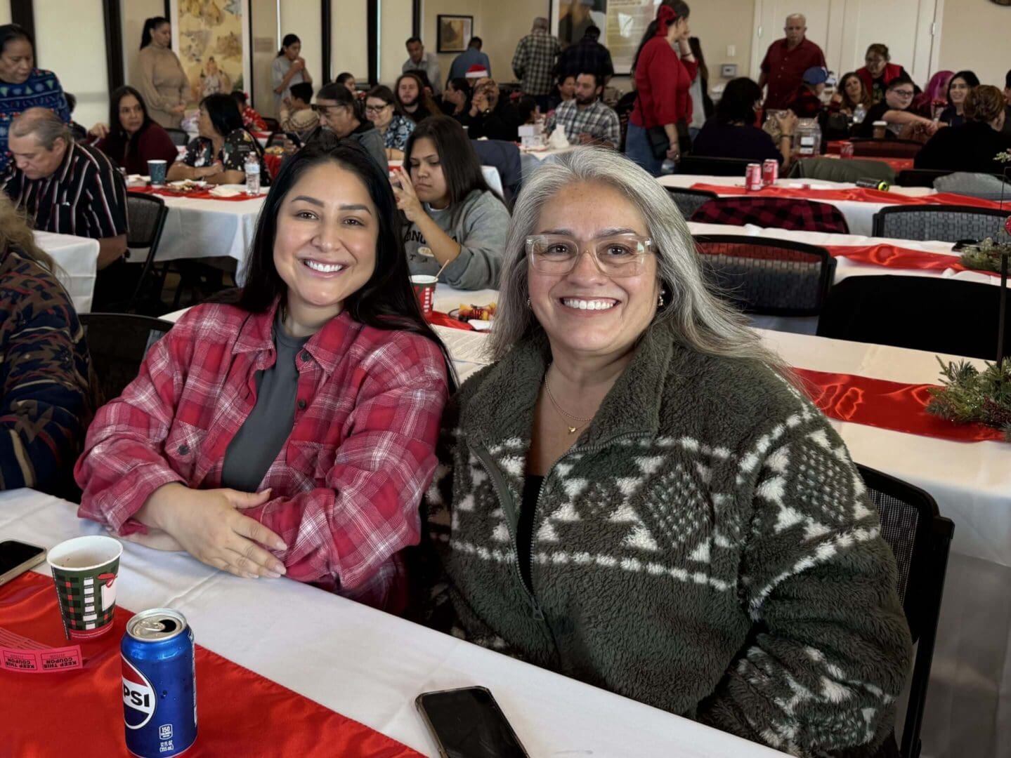 Two women smiling at a gathering.