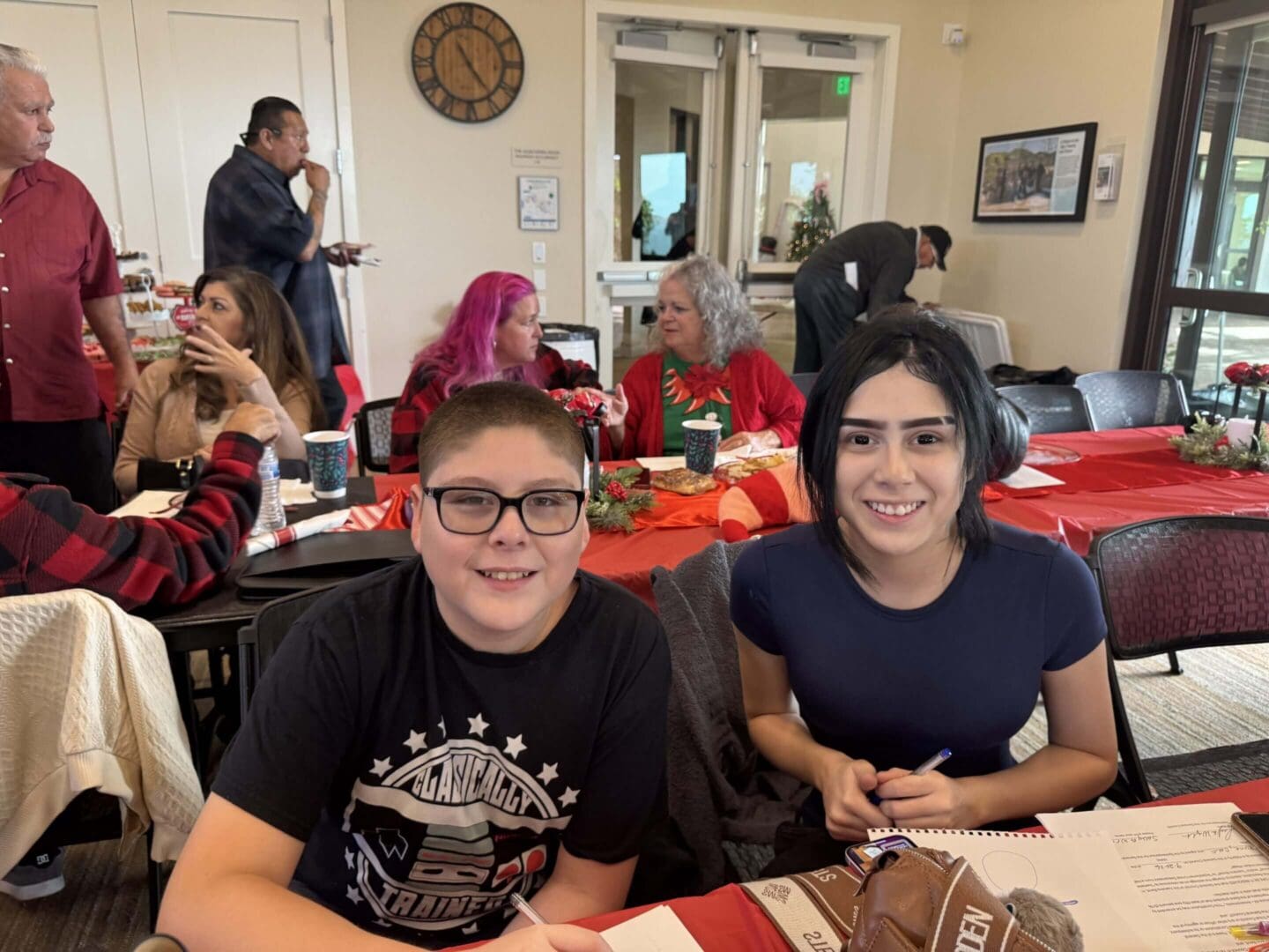 Two people smiling at a festive gathering.