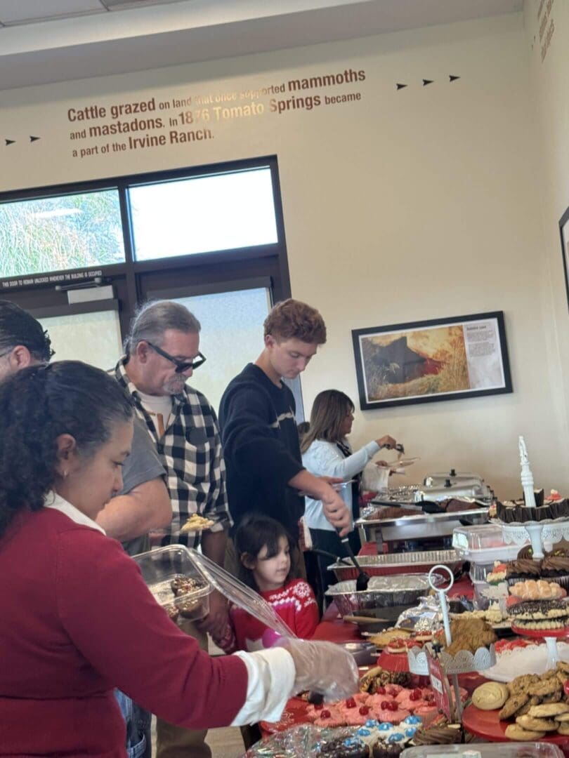 People serving food at a buffet table.